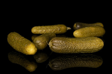 Group of six whole sour green pickle isolated on black glass