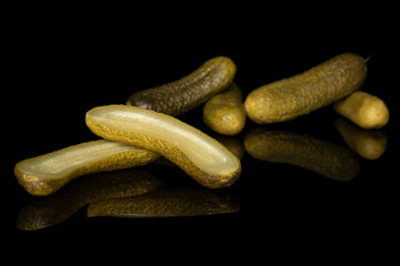 Group of four whole two halves of sour green pickle isolated on black glass