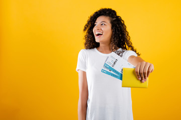 smiling happy black woman with plane tickets and passport isolated over yellow