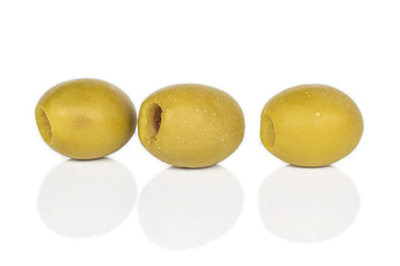 Group of three whole marinated green olive isolated on white background