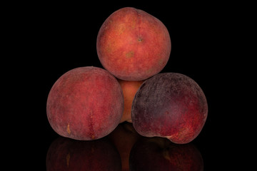 Group of four whole sweet red peach isolated on black glass