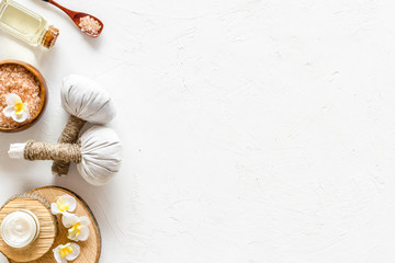 Spa set with massage herbal balls in wellness salon on white background top view copy space