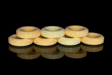 Group of seven whole round pale yellow candy isolated on black glass