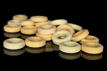 Fototapeta na wymiar Lot of whole round pale yellow candy isolated on black glass