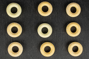 Fototapeta premium Group of nine whole round pale yellow candy flatlay on grey stone