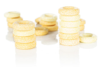 Lot of whole round pale yellow candy front focus isolated on white background