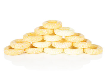Lot of whole round pale yellow candy pyramid isolated on white background