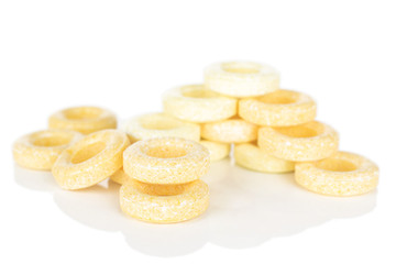 Lot of whole folded round pale yellow candy isolated on white background