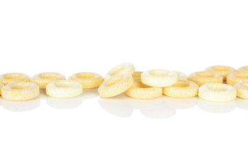 Lot of whole round pale yellow candy in row isolated on white background