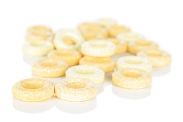 Lot of whole round pale yellow candy stack isolated on white background