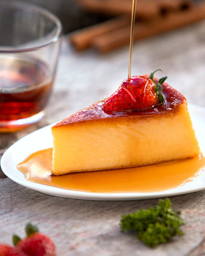 Chorro de miel cayendo sobre delicioso flan de leche y fresa 
