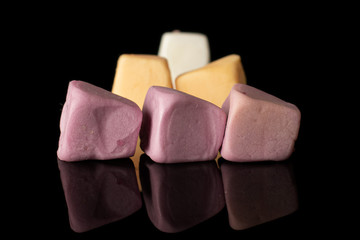 Group of six whole soft pastel candy isolated on black glass