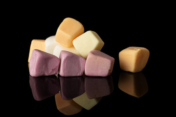 Lot of whole soft pastel candy isolated on black glass