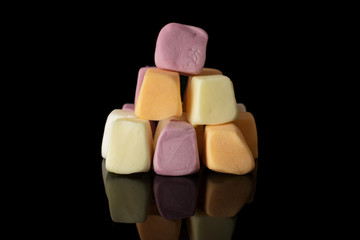 Lot of whole soft pastel candy isolated on black glass