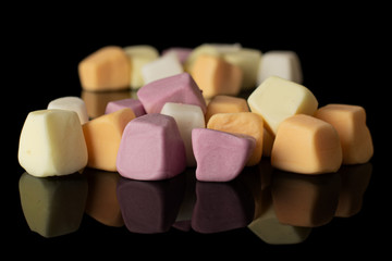 Lot of whole soft pastel candy isolated on black glass