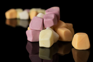 Lot of whole soft pastel candy heap isolated on black glass