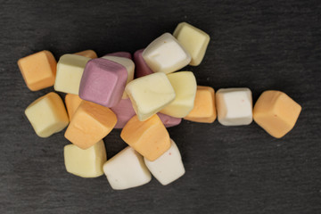 Lot of whole soft pastel candy heap flatlay on grey stone