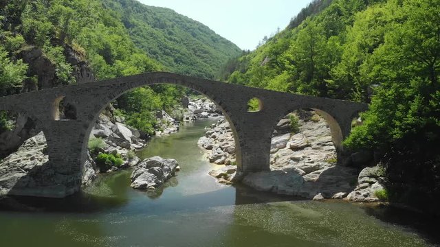 Aerial pull out flying away from Devil's Bridge over Arda River in Bulgaria.