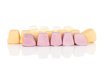Lot of whole soft pastel candy in row isolated on white background