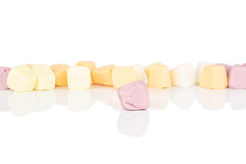 Lot of whole soft pastel candy in row isolated on white background