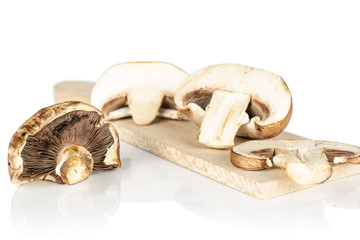 Fototapeta na wymiar Group of one whole two halves one slice of fresh brown mushroom champignon on wooden cutting board isolated on white background