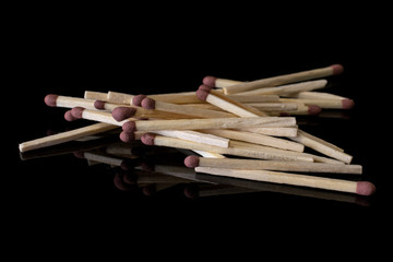 Lot of whole brown safety match isolated on black glass