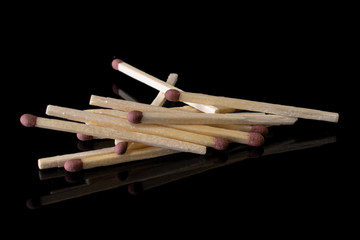 Lot of whole brown safety match isolated on black glass
