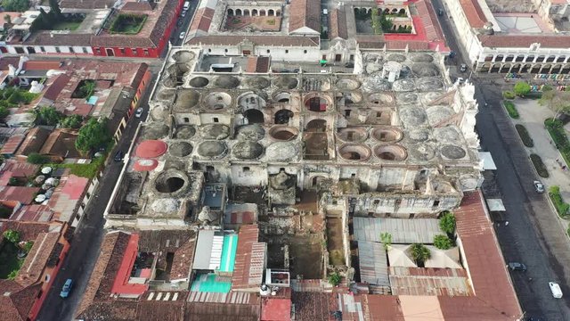 Aerial Drone view of Antigua in Guatemala. Flying forward over Unesco protected Catedral de Santiago destroyed by earthquake and Antigua main square Parque Central. Beautiful roman catholic catedral.
