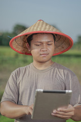 Asian farmers oversee his fields with sophisticated technology