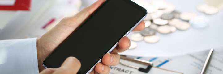 A businessman holds a new smartphone