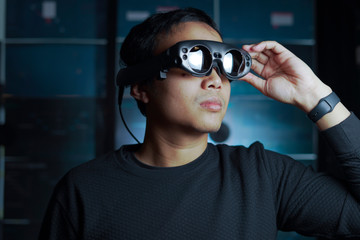 close up man wearing AR glasses in a dark room
