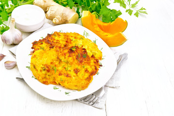 Pancakes of pumpkin in plate on light board