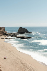 Pacific beach landscape and person standing in the waves