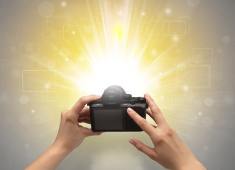 Naked hand taking picture with digital camera and glowing flash concept