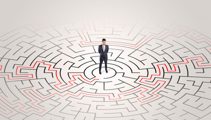 Young entrepreneur standing in a middle of a labyrinth with the solution