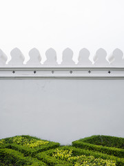 White wall of the Grand Palace with green bush, vertical, Bangkok Thailand © YUU-ME