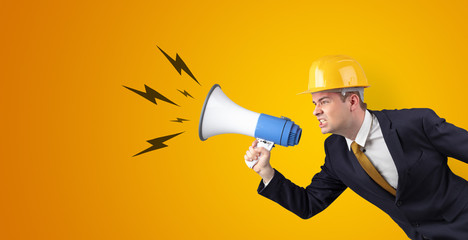 Fototapeta premium Young architect constructor yelling with megaphone and copyspace