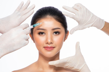 Asian young woman gets injection  in her lips. Woman in beauty salon. plastic surgery...