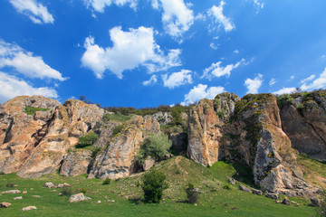 Fototapeta na wymiar Beautiful rock formations in a canyon in Romania, on a summer day, profiled on deep blue sky with cumulus clouds