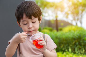 Every little child love eating sweets or snack. Cute or handsome little boy eat gelatin or jelly....