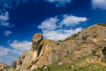 Fototapeta na wymiar Beautiful rock formations in a canyon in Romania, on a summer day, profiled on deep blue sky with cumulus clouds