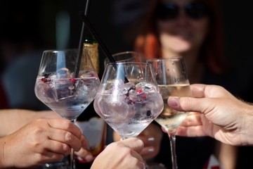 Closeup of cocktail in elegant glasses - group of people toasting
