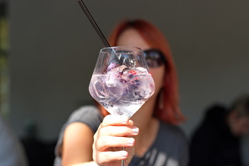 Elegant glass with cocktail in front of mature woman - woman holding glass with cocktail