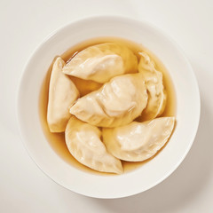 Simple bowl of dumpling soup with white background