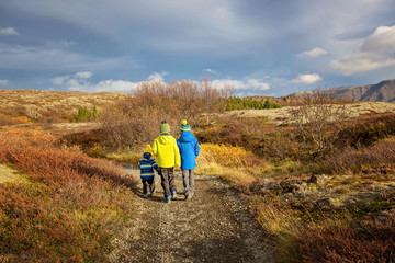 Children, brothers, walking on a path in scenic Thingvellir National Park rift valley, Iceland