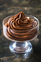 chocolate mousse cream dessert in a glass vase on a dark background