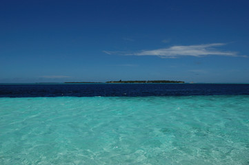The ridge of an island seen through the clear waters of the Maldives
