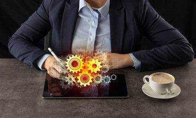 Business woman working on tablet with setting and gear concept