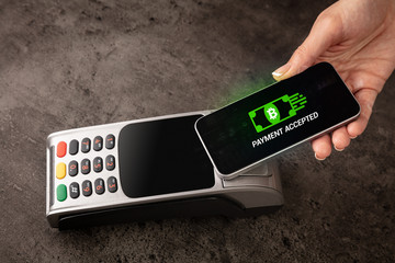Hand paying with digital currency from smartphone