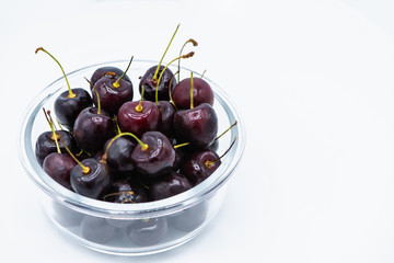 Red cherry fruit in glass bowl  on white background.